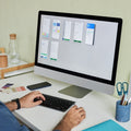 Person using a computer with a colorful display on a desk.