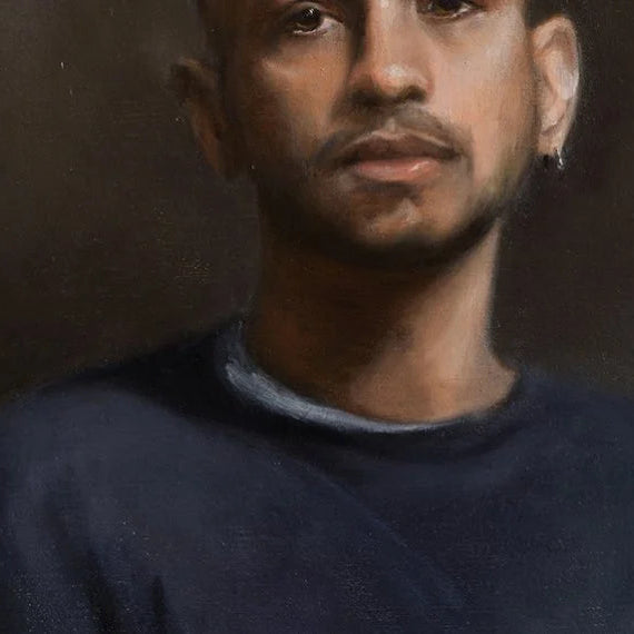 Portrait of a person wearing a dark sweater against a dark background